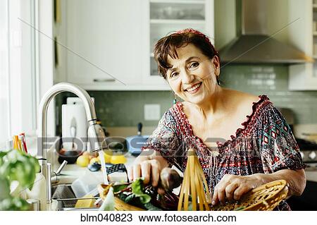 Caucasian woman with produce basket in kitchen View Large Photo Image Stock Image - Caucasian woman with produce basket in kitchen. Fotosearch