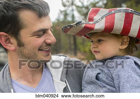 Father carrying daughter in patriotic hat View Large Photo Image Picture - Father carrying daughter in patriotic hat. Fotosearch