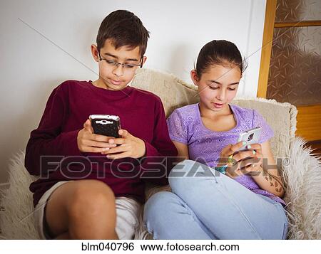 Stock Photograph - Mixed race children using cell phones. Fotosearch