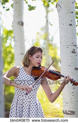 Stock Image - Mixed race musician playing violin outdoors. Fotosearch