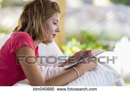 Stock Image - Mixed race woman using digital tablet. Fotosearch