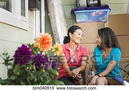 Stock Photo - Women smiling outside house. Fotosearch