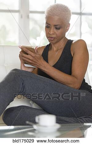 Stock Photo - African American woman using cell phone. Fotosearch