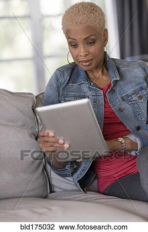 Stock Image - African American woman using digital tablet. Fotosearch