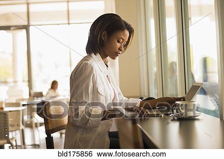 African American woman using laptop in cafe View Large Photo Image Stock Photograph - African American woman using laptop in cafe. Fotosearch