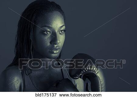 Stock Photo - African American woman wearing boxing gloves. Fotosearch