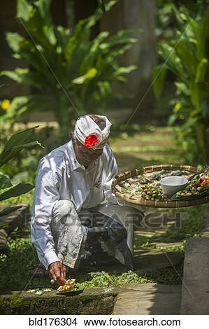 Picture - Asian artist creating sculptures on stone walkway. Fotosearch