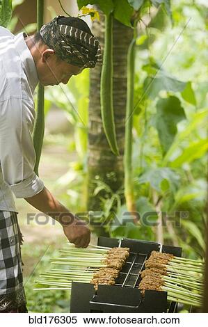 Stock Photography - Asian chef cooking on grill outdoors. Fotosearch