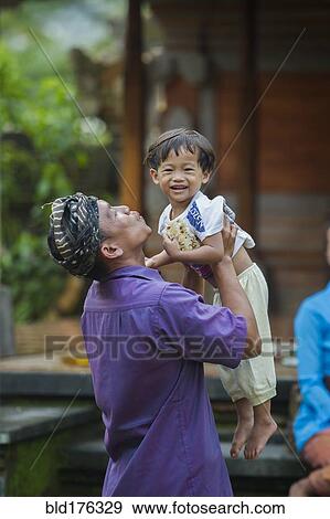 Stock Photo - Asian father playing with son outdoors. Fotosearch