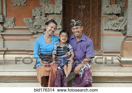 Picture - Asian mother, father and son smiling outside ornate building. Fotosearch
