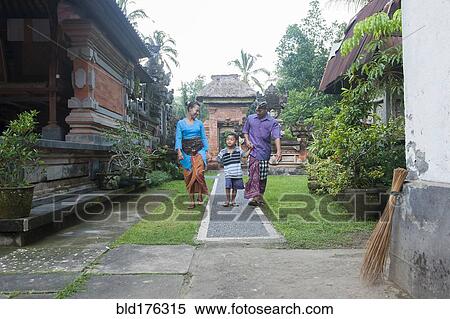 Stock Photography - Asian mother, father and son walking outside ornate building. Fotosearch