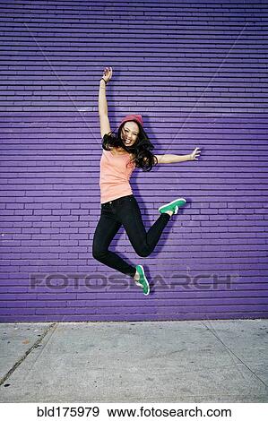 Stock Photo - Asian woman jumping for joy. Fotosearch