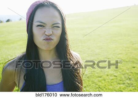Asian woman making a face outdoors View Large Photo Image Stock Image - Asian woman making a face outdoors. Fotosearch