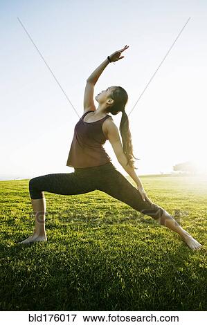 Stock Photo - Asian woman practicing yoga outdoors. Fotosearch