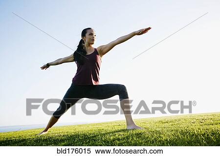 Stock Photography - Asian woman practicing yoga outdoors. Fotosearch