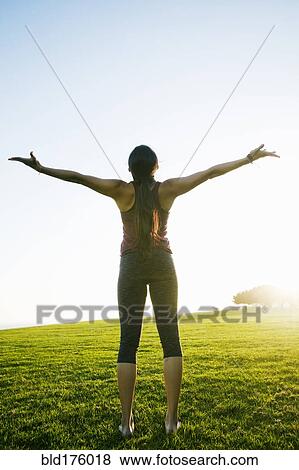 Stock Photo - Asian woman standing with arms outstretched. Fotosearch