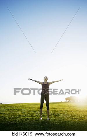 Stock Photo - Asian woman standing with arms outstretched. Fotosearch