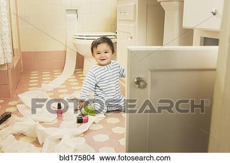 Picture - Baby boy playing in messy bathroom. Fotosearch