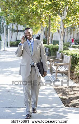 Black businessman talking on cell phone outdoors View Large Photo Image Stock Image - Black businessman talking on cell phone outdoors. Fotosearch