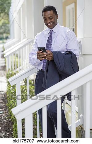 Stock Photo - Black businessman using cell phone. Fotosearch