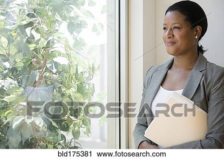 Black businesswoman looking out window View Large Photo Image Stock Image - Black businesswoman looking out window. Fotosearch