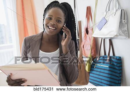Stock Image - Black businesswoman talking on cell phone. Fotosearch