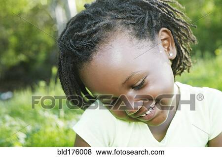 Stock Photo - Black girl smiling outdoors. Fotosearch
