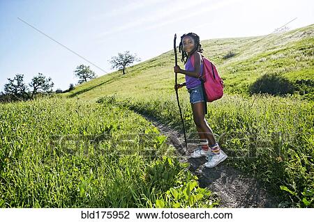 Stock Image - Black girl walking on rural path. Fotosearch