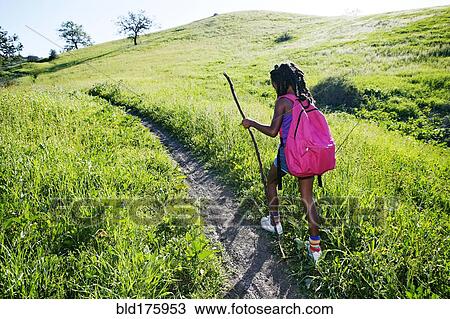 Stock Image - Black girl walking on rural path. Fotosearch