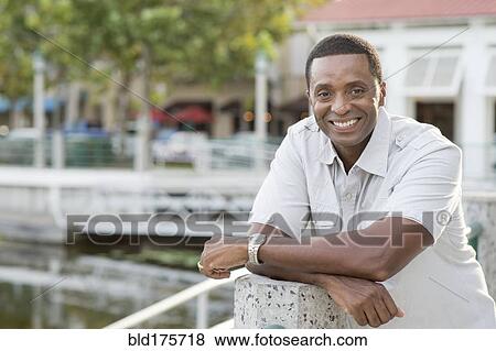 Black man smiling at marina View Large Photo Image Stock Photo - Black man smiling at marina. Fotosearch
