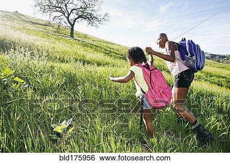 Black mother and daughter walking on rural hillside View Large Photo Image Stock Photograph - Black mother and daughter walking on rural hillside. Fotosearch