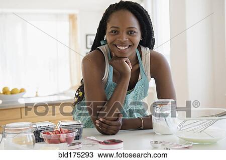 Stock Image - Black woman baking in kitchen. Fotosearch