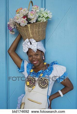 Stock Image - Black woman balancing basket on her head. Fotosearch
