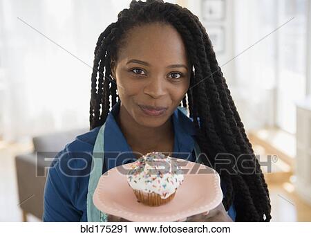 Black woman holding cupcake on plate View Large Photo Image Stock Image - Black woman holding cupcake on plate. Fotosearch