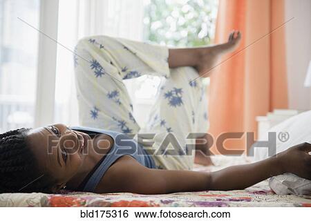 Black woman laying on bed View Large Photo Image Stock Photograph - Black woman laying on bed. Fotosearch