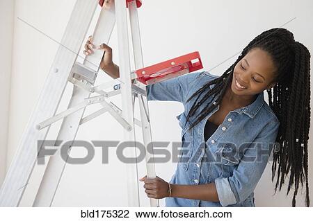 Stock Image - Black woman opening ladder. Fotosearch