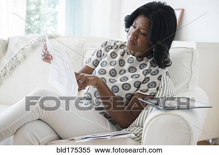 Black woman reading bills on sofa View Large Photo Image Stock Photography - Black woman reading bills on sofa. Fotosearch