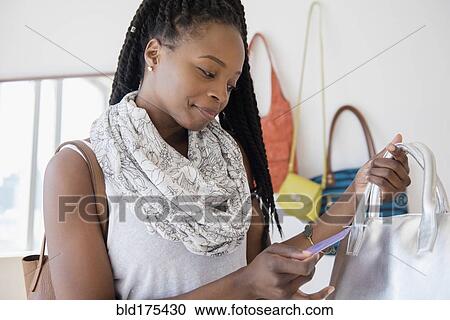 Stock Image - Black woman shopping in store. Fotosearch