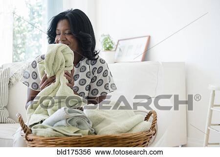 Black woman smelling clean laundry View Large Photo Image Stock Photograph - Black woman smelling clean laundry. Fotosearch