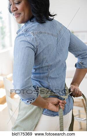 Black woman tying apron around waist View Large Photo Image Stock Photo - Black woman tying apron around waist. Fotosearch