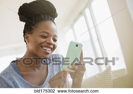 Stock Image - Black woman using cell phone. Fotosearch