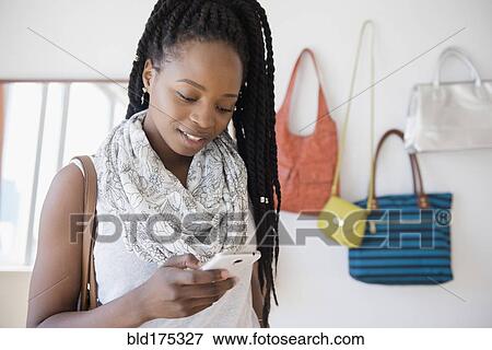 Stock Photo - Black woman using cell phone. Fotosearch