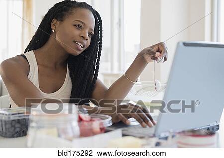 Stock Image - Black woman using laptop. Fotosearch