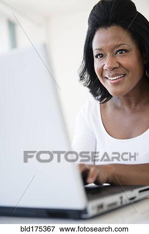 Stock Photo - Black woman using laptop. Fotosearch