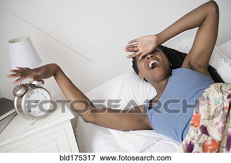 Black woman waking up with alarm clock View Large Photo Image Stock Photo - Black woman waking up with alarm clock. Fotosearch