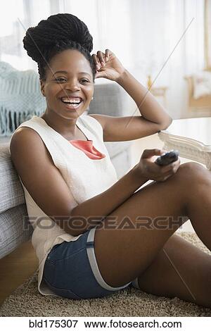 Stock Photo - Black woman watching television. Fotosearch