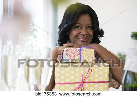 Black woman with gifts at party View Large Photo Image Stock Image - Black woman with gifts at party. Fotosearch