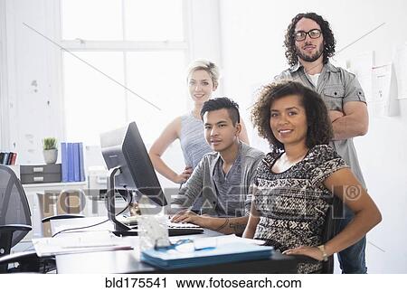 Stock Image - Business people smiling in office. Fotosearch