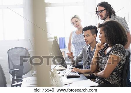 Stock Image - Business people working together in office. Fotosearch