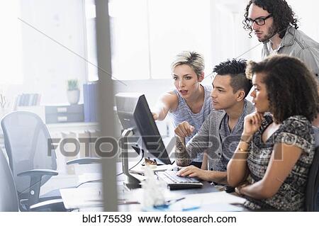 Stock Photo - Business people working together in office. Fotosearch